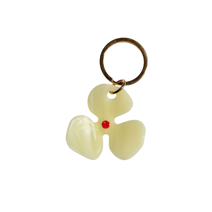 Meet FLOR!  A bleached lemon yellow flower with an orange jewel in the centre and Tort logo embossed on the back. Complete with brass-gold keyring hardware so you're able to attach to keys.  Each keyring comes in a branded Tort pouch (colours change seasonally).  Size: 4.5cm  Colour: bleached lemon yellow with orange jewel  Material: eco-resin